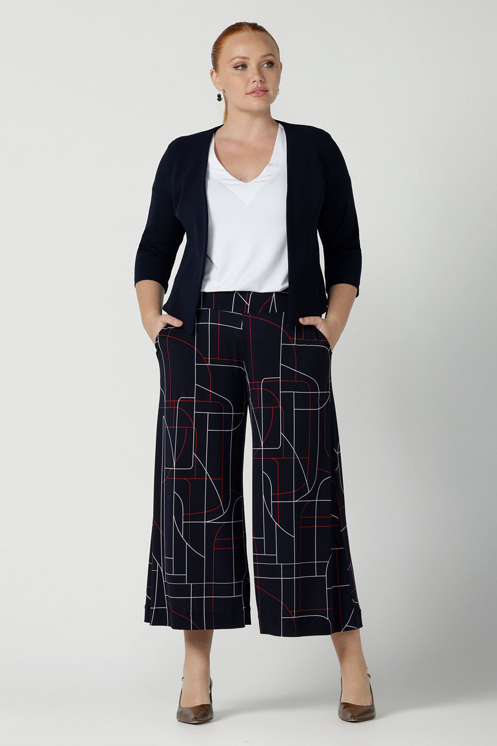 A size 12 woman wears the Dany Culotte in Navy Abstract. Corporate comfortable pant for women, geometric print with navy, red and white. Made in Australia for women size 8 - 24.
