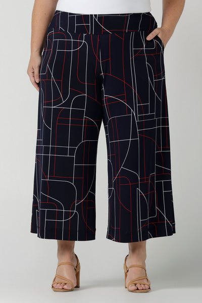 A size 12 woman wears the Dany Culotte in Navy Abstract. Corporate comfortable pant for women, geometric print with navy, red and white. Made in Australia for women size 8 - 24.