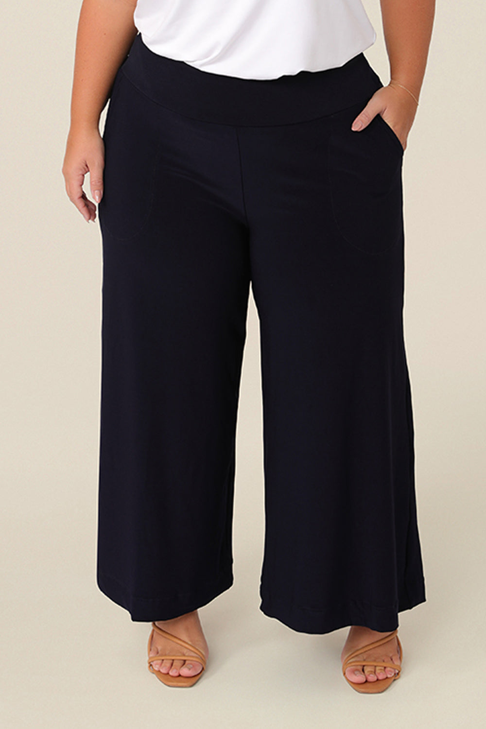 Good pants for petite women, black culotte pants by Australian fashion brand, Leina & Fleur, are shown on a curvy, size 16 woman. Cropped trousers with a stretchy, pull on waistband, these easy-care wide leg pants are worn with a short sleeve top in white bamboo jersey.