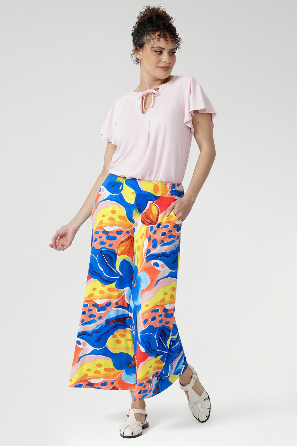 Crafted from our cool-touch slinky jersey, the Dany Culotte in Summer Bliss features a striking abstract print set against a fresh white base. With its wide-leg silhouette and fluid drape, this piece moves beautifully from day to night. Designed for ease with a pull-on waistband and practical side pockets, it delivers both comfort and effortless sophistication — perfect for work, travel, or relaxed weekends.