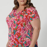 Side view of summer ready top worn by plus sized model features a short sleeves, cowl neckline and shirt tail hemline. Adding a touch of elegance to your casual look, with the versatility to be dressed up or dow. Proudly Australian-made, it's ideal for warm-weather days, whether you're lounging poolside or exploring a coastal town. Leina & Fleur proudly stock sizes 8-24.