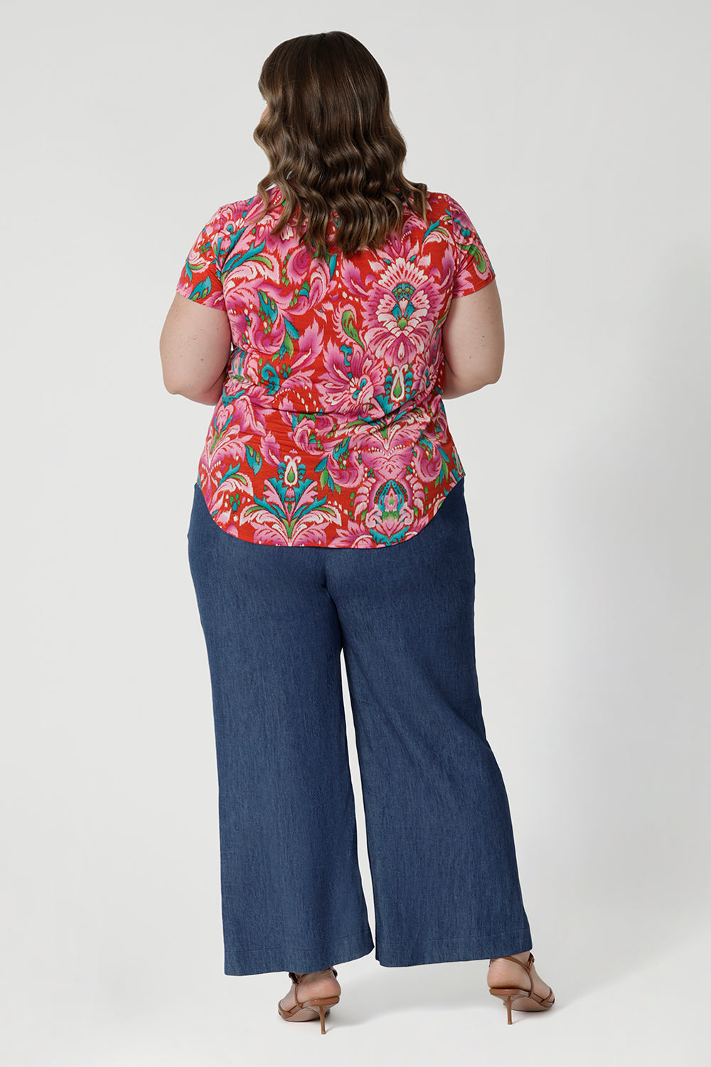 The fabric used for summer ready top has stretch, providing a flattering, flexible fit that moves with you. Its effortless design and relaxed silhouette make it a versatile addition to your summer wardrobe, ideal for both daytime adventures and evening strolls by the shore. Size 18 model showcases her Daryl top with her jeans and a brown heel for an elevated day look. 