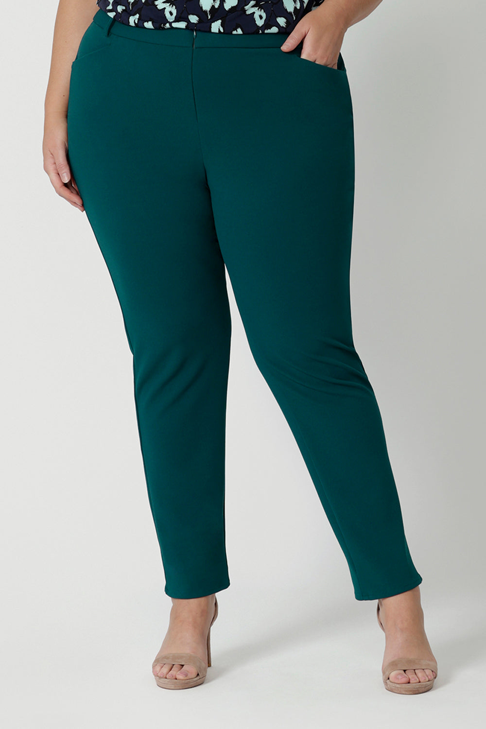 A good workwear pant for plus size women, this is a close up of a green tapered leg pant is shown on a size 18 woman. Worn with summer top women in printed jersey, these ankle length pants wear for work and casual wear. Trousers with stretch, Australia and New Zealand women's clothes label Leina & Fleur specialise in comfortable workwear for women in sizes 8 to 24.