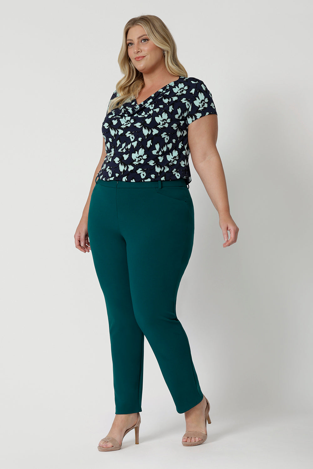 A good workwear pant for plus size women, this green tapered leg pant is shown on a size 18 woman. Worn with a cowl neck, short sleeve top in printed jersey, these ankle length pants wear for work and casual wear. Trousers with stretch, Australia and New Zealand women's clothes brand Leina & Fleur specialise in comfortable workwear for women in sizes 8 to 24.