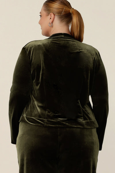Back view of a size 18, plus size woman wearing a waterfall front velour jacket for evening and cocktail wear. In bracken green this curve cocktail jacket is good for evening, occasion and wedding guest outfits. Shop made-in-Australian occasionwear in petite to plus sizes at Leina & Fleur.