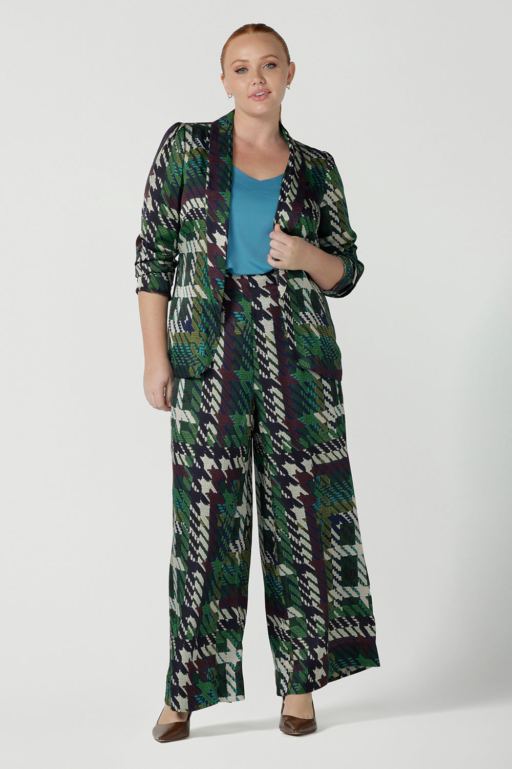 Size 12 woman wears a matching power suit in silk like fabric Italian Viscose. Tailored jacket and pants with soft tailoring details. Made in Australia for women size 8 - 24.
