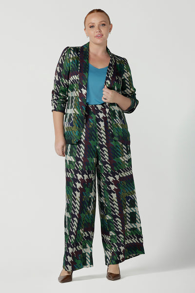 Size 12 woman wears a matching power suit in silk like fabric Italian Viscose. Tailored jacket and pants with soft tailoring details. Made in Australia for women size 8 - 24.