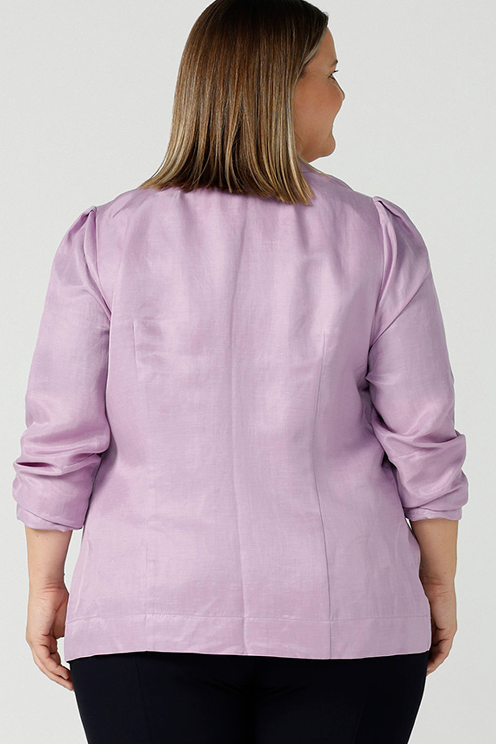 Back view of a size 18 curvy woman wears a linen blend blazer in lilac with a shawl collar. Soft tailoring details with shoulder tucks. Made in Australia size 8 - 24.