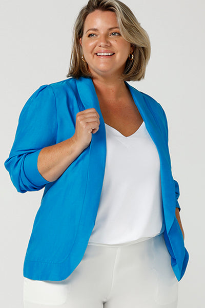 Close up of A curvy size, size 16 woman wearing a longline blazer in opal blue tencel fabric with a white bamboo cami. This lightweight jacket is comfortable for your everyday workwear, casual and travel capsule wardrobe. Shop this Australian-made blazer online in sizes 8 to 24, petite to plus sizes.