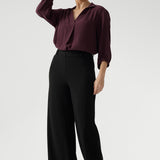 Full body back image of tall woman wearing. Black work wear pants. Easy care fabric used to craft pants is scuba crepe. Off duty pants provide breathable stretch and comfort. Australia Made for woman in Australia and New Zealand. Leina & Fleur is a woman’s clothing brand that has sizes ranging from 8 to 24 including plus sizes and petite sizes. 