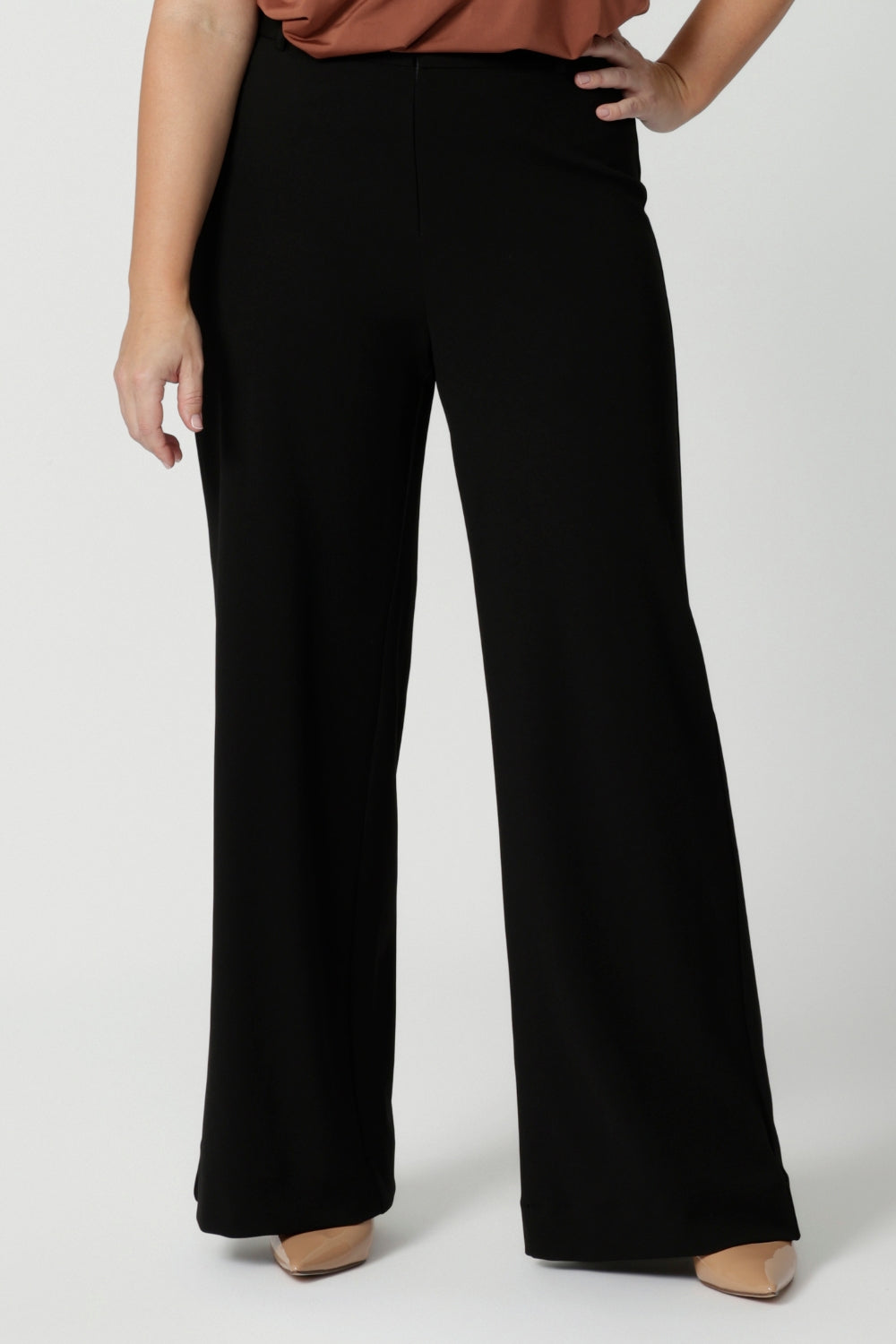 Close up image of size 12 model wearing easy care pants made of scuba crepe fabric that provide breathability and stretch around the body. The perfect work wear pant style, also has a matching blazer for a full suit look. Made in Australia for women sized 8 through to 24. 