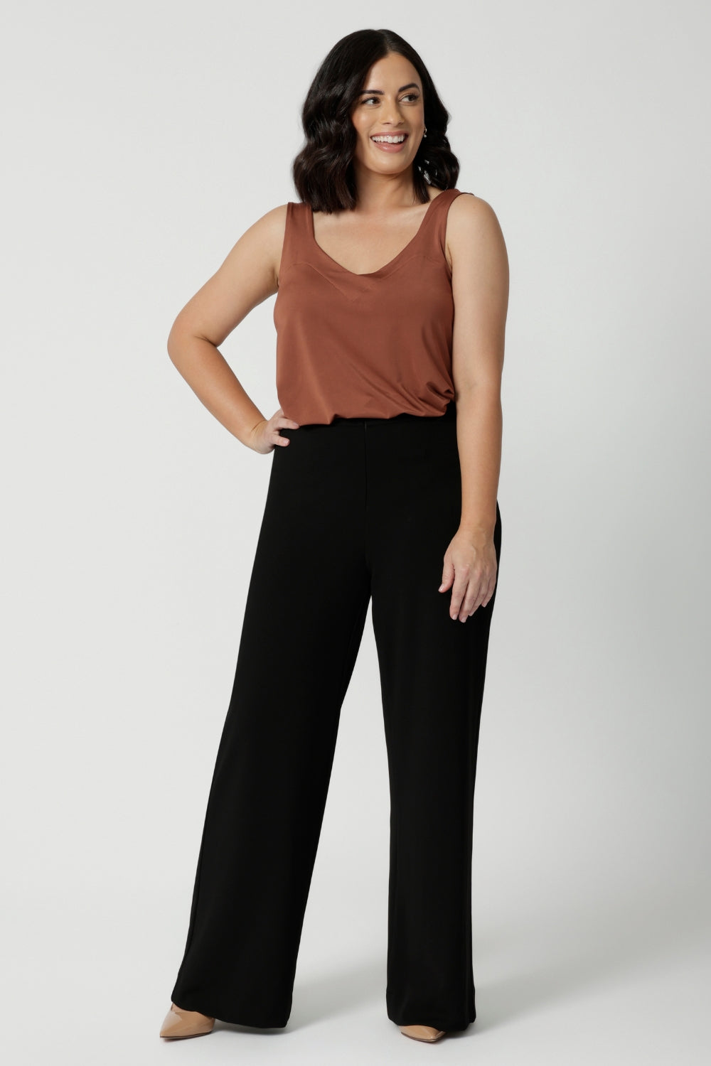 Image of petite model wearing easy care pants made of scuba crepe fabric. The perfect work wear pants made in Australia for women sized 8 - 24. 
Designed with a slow fashion focus. Leina & Fluer prioritise sustainability making these pants a staple for any wardrobe, whether you're in the office or enjoying a casual day out, these versatile black pants ensure you always look effortless.