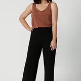 Image of petite model wearing easy care pants made of scuba crepe fabric. The perfect work wear pants made in Australia for women sized 8 - 24. 
Designed with a slow fashion focus. Leina & Fluer prioritise sustainability making these pants a staple for any wardrobe, whether you're in the office or enjoying a casual day out, these versatile black pants ensure you always look effortless.