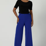 The Drew Pant in Cobalt Scuba Crepe with a wide leg Cobalt pant with a high waist that can be worn with the matching Blazer. Comfortable and easy care suit set for women. Size 8-24. Styled back a black fitted round neckline top. 