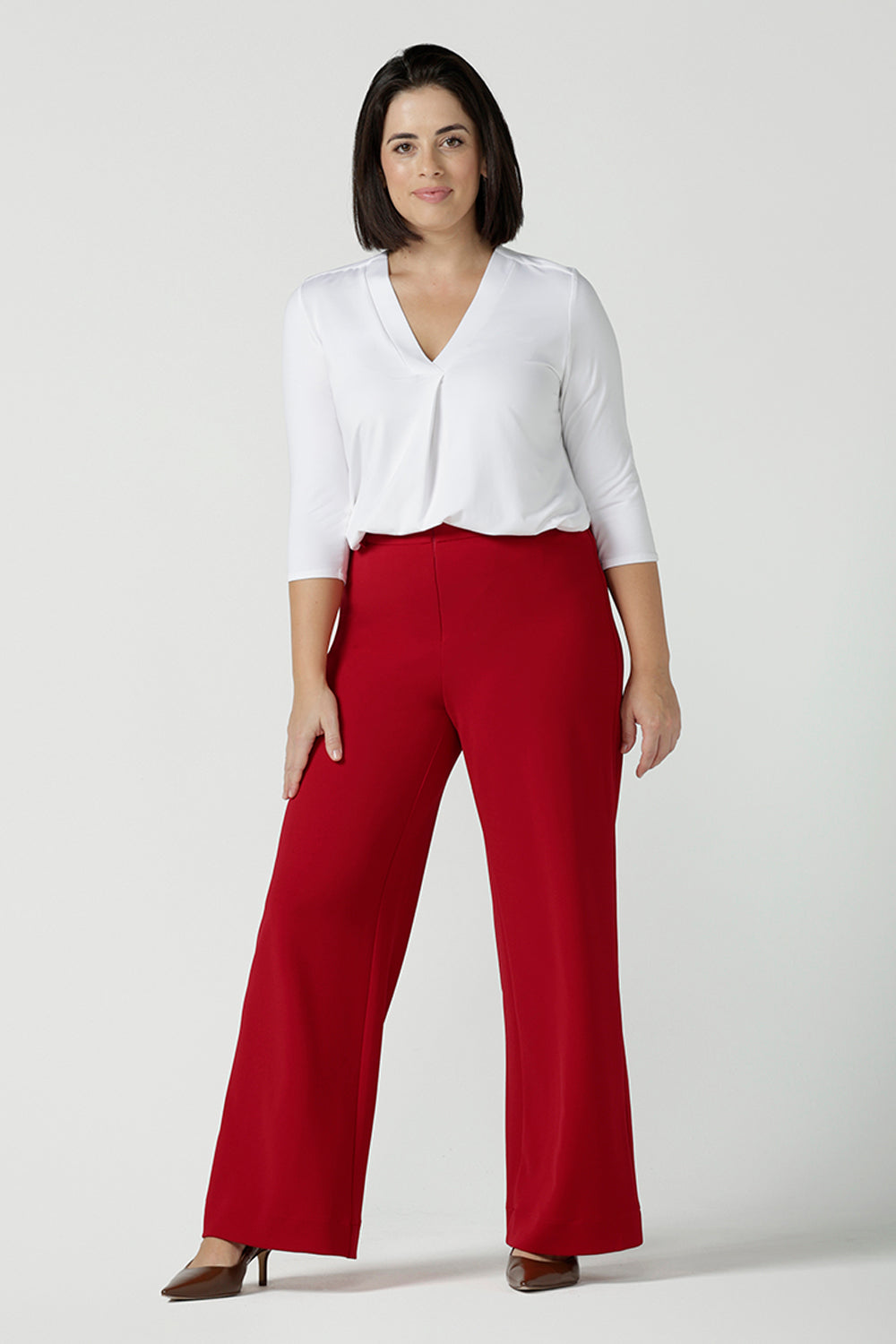 A size 10 woman wears the Drew pant in red, high waist and invisible fly front. Tailored belt loops and wide leg. Made in Australia for women. Stylish corporate wear for women. Made in Australia size 8 - 24.