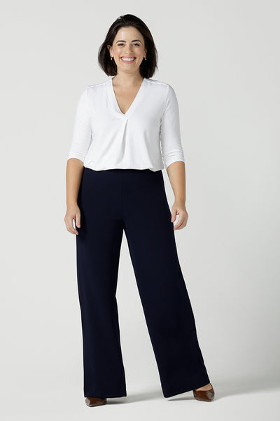 Size 10 model wears the Navy wide leg pant with navy scuba crepe. High waisted and tailored with belt loops. Stylish and corporate workwear for women size 8 - 24.. Made in Australia. Styled back with a white Jaime top in soft bamboo. 