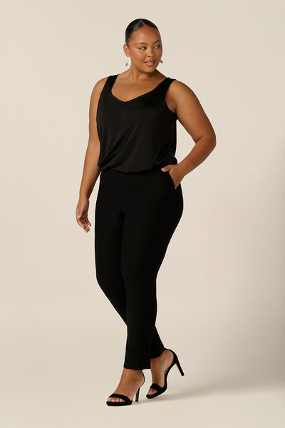 A size 18, fuller figure woman wears a black cami top with wide shoulder straps. Made in Australia by Australian and New Zealand women's clothing company, this slinky jersey top wears well with evening and occasionwear skirts, pants and suit jackets.