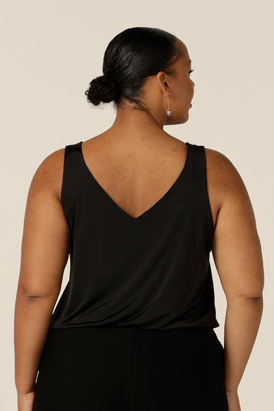 Back view of a size 18, fuller figure woman wears a black cami top with wide shoulder straps. Made in Australia by Australian and New Zealand women's clothing company, this slinky jersey top wears well with evening and occasionwear skirts, pants and suit jackets.