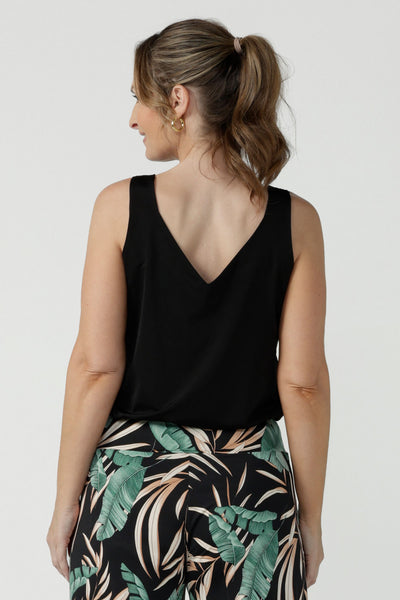 Back view of a size 8 woman wearing a black cami top with wide shoulder straps. Made in Australia for petite to plus size women size 8 - 24. This soft jersey top wears well with evening, smart casual and weekend wear skirts, pants and suit jackets.