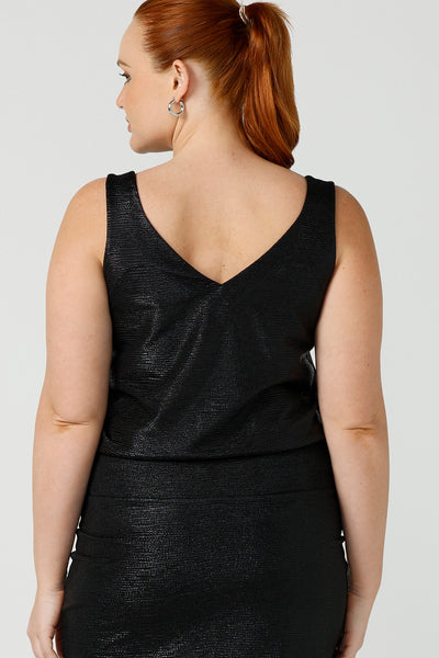 Back view of a size 12, fuller figure woman wearing a black Xanadu cami top with wide shoulder straps. Made in Australia by Australian and New Zealand women's clothing company, this shimmer jersey top wears well with evening and occasion-wear skirts, pants and suit jackets.