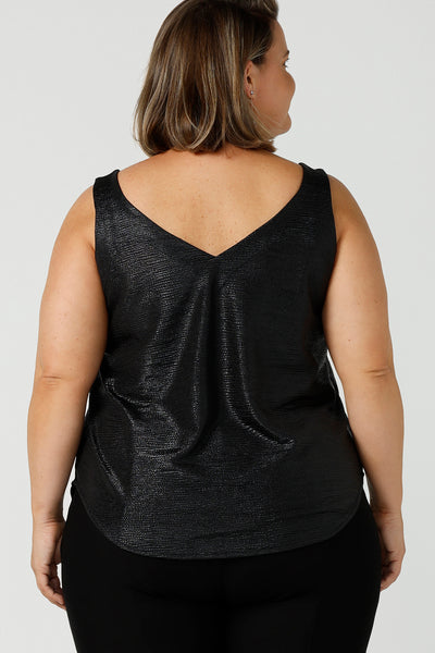 Back view of a plus size 18, fuller figure woman wearing a black Xanadu cami top with wide shoulder straps. Made in Australia by Australian and New Zealand women's clothing company, this shimmer jersey top wears well with evening and occasion-wear skirts, pants and suit jackets.