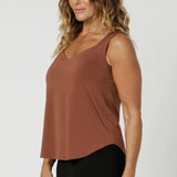 Summer ready cami top for off duty or event styling. Shown on size 12 woman, this cami top is worn with tapered leg black pants. Eddy Cami in Clay has wide shoulder straps, a soft V-neckline and loose fitting slinky jersey body. 