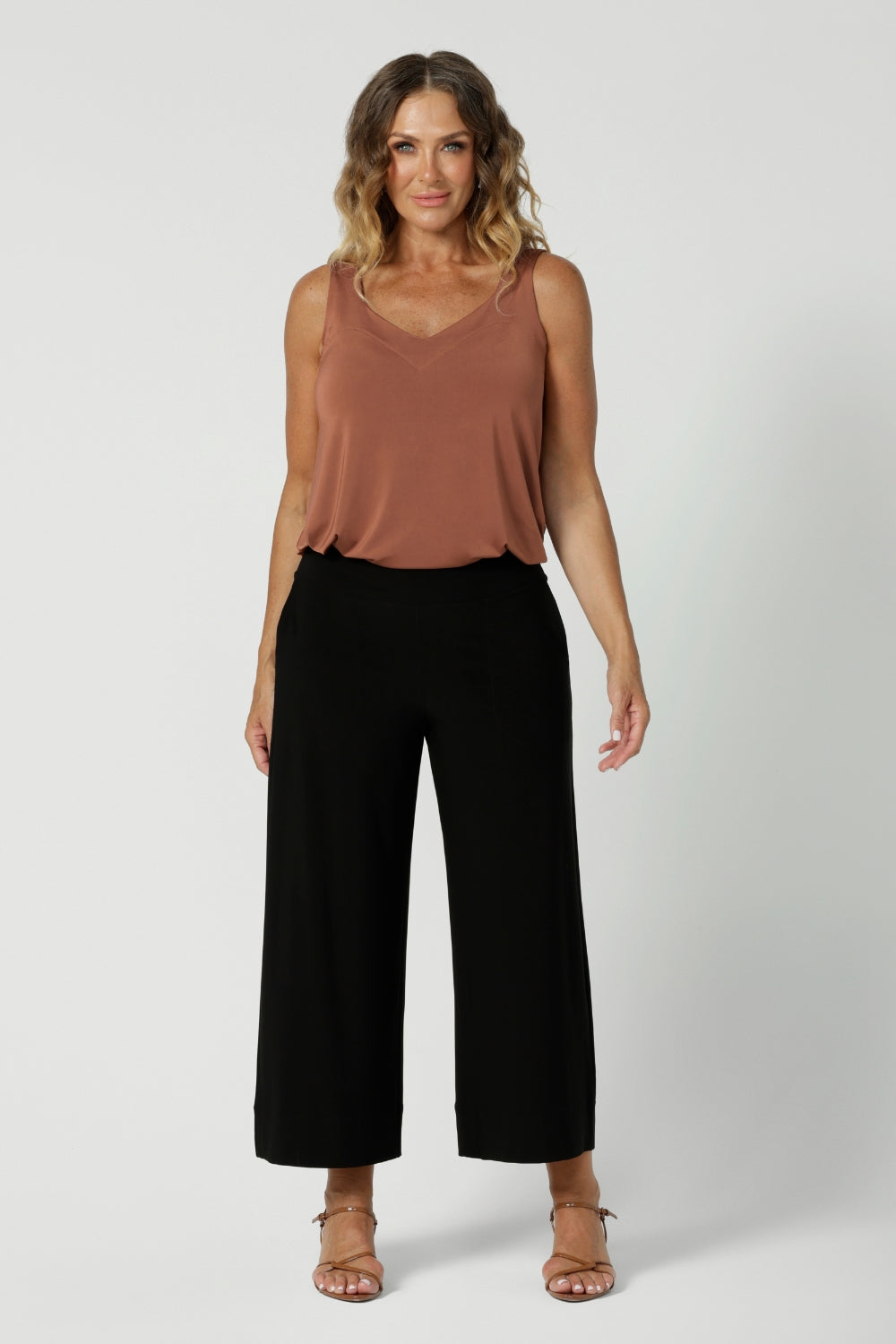 Summer ready cami top for off duty or event styling. Shown on size 12 woman, this cami top is worn with wide leg black pants. Eddy Cami in Clay has wide shoulder straps to help conceal bra straps. A soft V-neckline and loose fitting slinky jersey makeup.