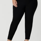 Close up of a size 18 Curvy woman wears the Brooklyn pant in black. It has a slim leg and functional pockets with invisible fly front detail. Styled back with an Eddy cami in Mineral. Made in Australia for women size 8 - 24.