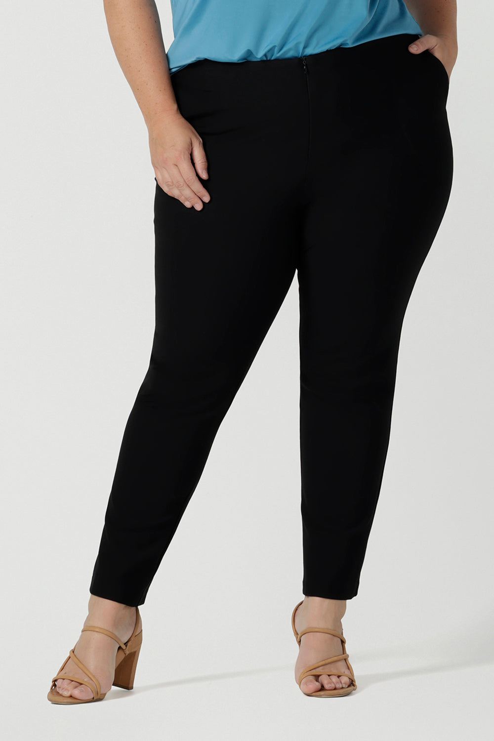 Close up of a size 18 Curvy woman wears the Brooklyn pant in black. It has a slim leg and functional pockets with invisible fly front detail. Styled back with an Eddy cami in Mineral. Made in Australia for women size 8 - 24.