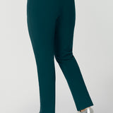 Back view of good workwear pants for over 40 women. A size 12 woman wears a cropped, ankle length pants in green scuba crepe jersey with a navy cami. Good pants for work, these trousers are made from stretchy jersey and are comfortable for all-day wear. Made in Australia by Australian and New Zealand women's clothes brand, Leina & Fleur, shop easy-care workwear for petite to plus size women. 