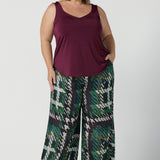 Size 18 woman wears the Eddy Cami top in Plum with wide straps. Made in Australia for women size 8 -24. style back with high waist Lulu pants in Navy. Soft tailored pants.