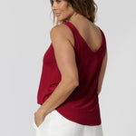 Back view of model wearing red cami made of slinky jersey fabric that is easy care and breathable. Lightweight cami offers a luxe feel perfect for summer celebrations, ensuring you stay cool and fashionable all season long. Made in Australia by fashion label Leina & Fleur. Sizes 8-24.