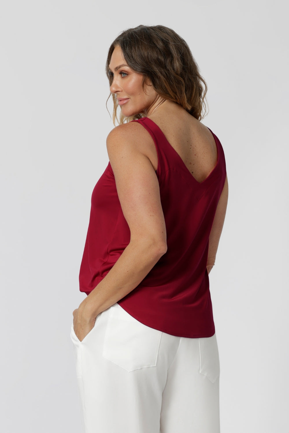 Back view of model wearing red cami made of slinky jersey fabric that is easy care and breathable. Lightweight cami offers a luxe feel perfect for summer celebrations, ensuring you stay cool and fashionable all season long. Made in Australia by fashion label Leina & Fleur. Sizes 8-24.