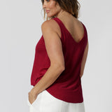 Back view of model wearing red cami made of slinky jersey fabric that is easy care and breathable. Lightweight cami offers a luxe feel perfect for summer celebrations, ensuring you stay cool and fashionable all season long. Made in Australia by fashion label Leina & Fleur. Sizes 8-24.