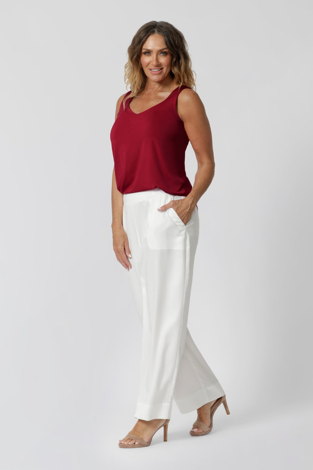 Over 40 year old woman wears light weight red cami made from high-quality slinky jersey fabric. Lightweight cami is paired with our Connor Pants in white for a summer ready casual outfit. This red cami has been designed for you to stay cool and fashionable all season long. Proudly made in Australia by Leina & Fleur brand, sizes 8-24.