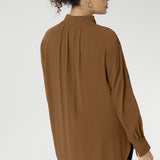 Plus size woman wears lightweight, easy to wear shirt that holds its shape without stretch. In the warm neutral shade of Nuthatch, it brings subtle sophistication to everyday dressing.
Available in size 8-24.