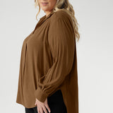 Plus size woman wears lightweight, easy to wear shirt that holds its shape without stretch. In the warm neutral shade of Nuthatch, it brings subtle sophistication to everyday dressing.
Available in size 8-24.