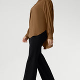 The full-length sleeves are finished with clean cuffs and covered buttons — an understated touch that elevates the look. A gently curved shirttail hem sits longer at the back, offering balanced proportions and flattering coverage.