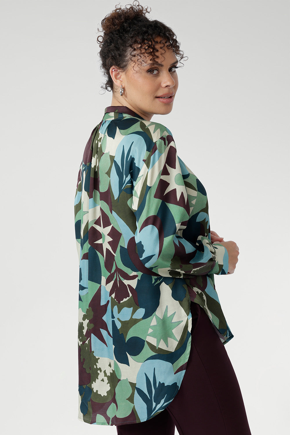 A sophisticated collared V-neckline with tailored centre tuck adds structure, while the full-length cuffed sleeves with covered buttons bring a polished finish. Long shirt tail hem for dramatic movement. Available in sizes 8-24.
