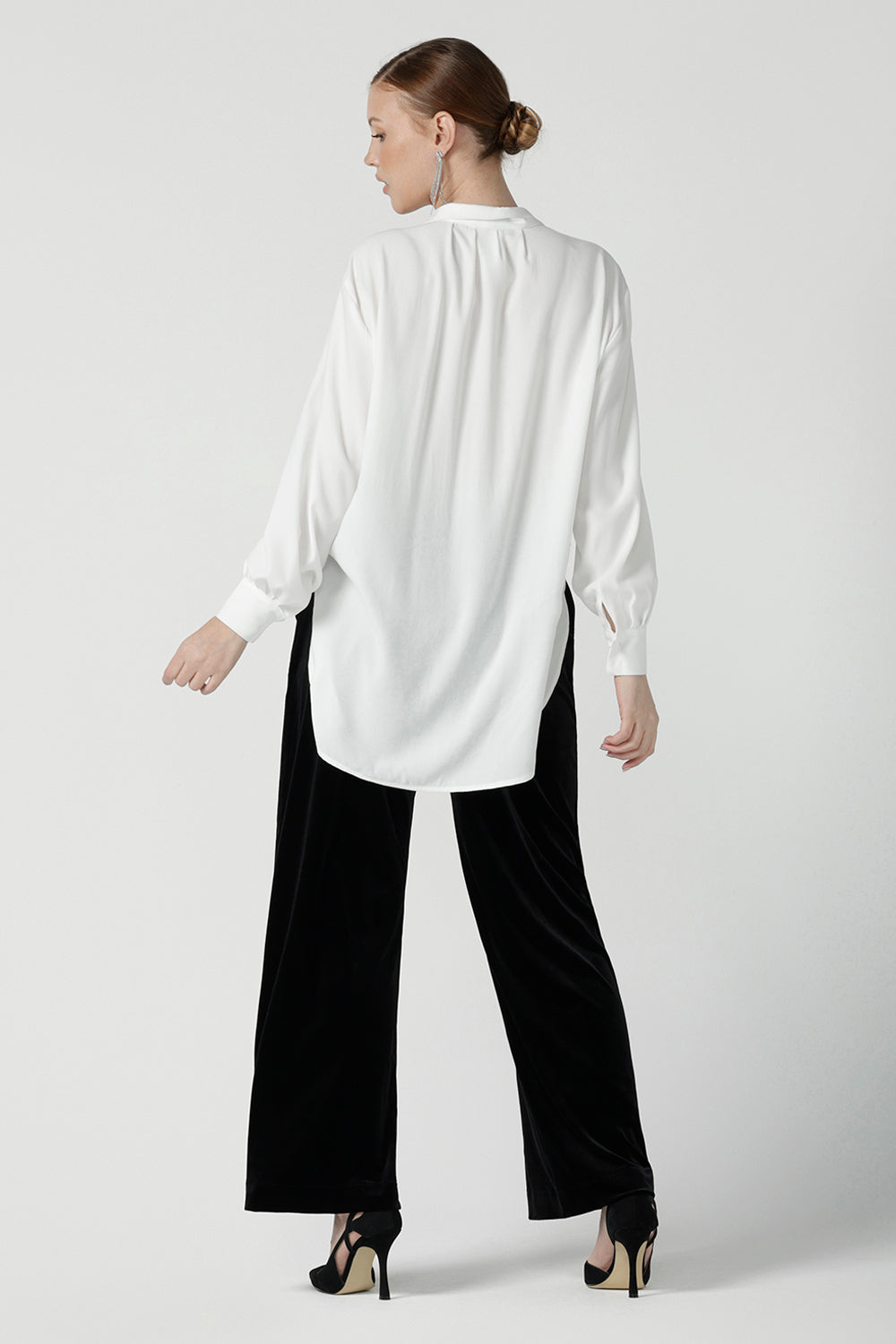 Back view of a size 10 woman wears the Ellis shirt in Vanilla tencel, a high quality made in Australia womens shirt made in breathable tencel. Inclusive size range 8-24 and made in Australia. Styled back with the Deni pants in Black velour.