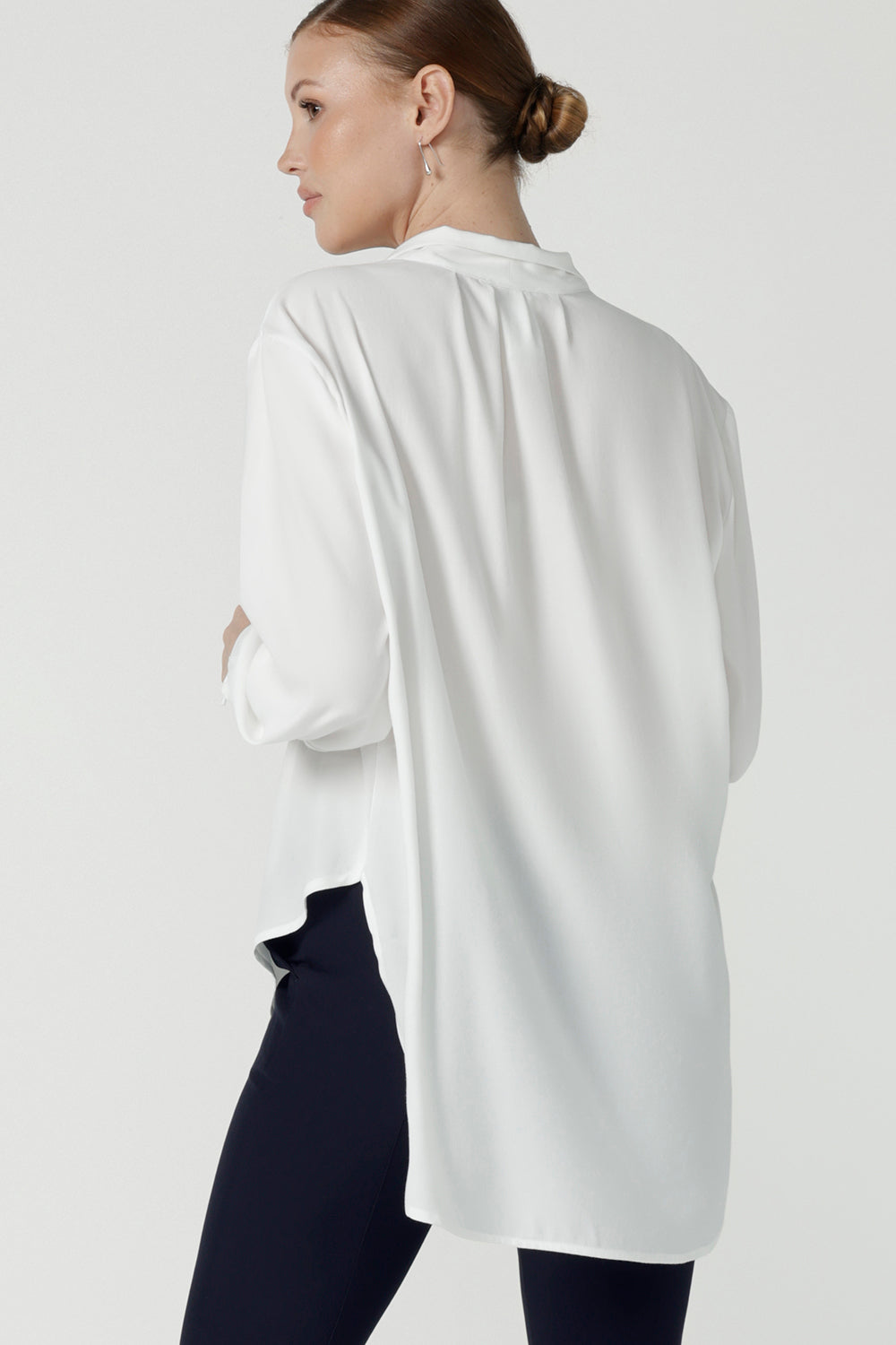 Back view of a size 10 woman wears the Ellis shirt in Vanilla tencel, a high quality made in Australia womens shirt made in breathable tencel. Inclusive size range 8-24 and made in Australia. Styled back with the Diaz pant in navy ponte.