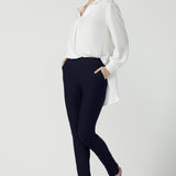 A size 10 woman wears the Ellis shirt in Vanilla tencel, a high quality made in Australia womens shirt made in breathable tencel. Inclusive size range 8-24 and made in Australia. Styled back with the Diaz pant in navy ponte.