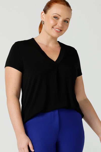 A good top for your capsule wardrobe, this V-neck black bamboo jersey top with short sleeves makes for a good office wear top for women, as well as a comfortable casual top. Shown on a size 12 woman, this top is made for fuller figure women by Australian women's clothing brand, Leina & Fleur. Shop black tops for women in sizes 8 to 24 in their online fashion boutique.