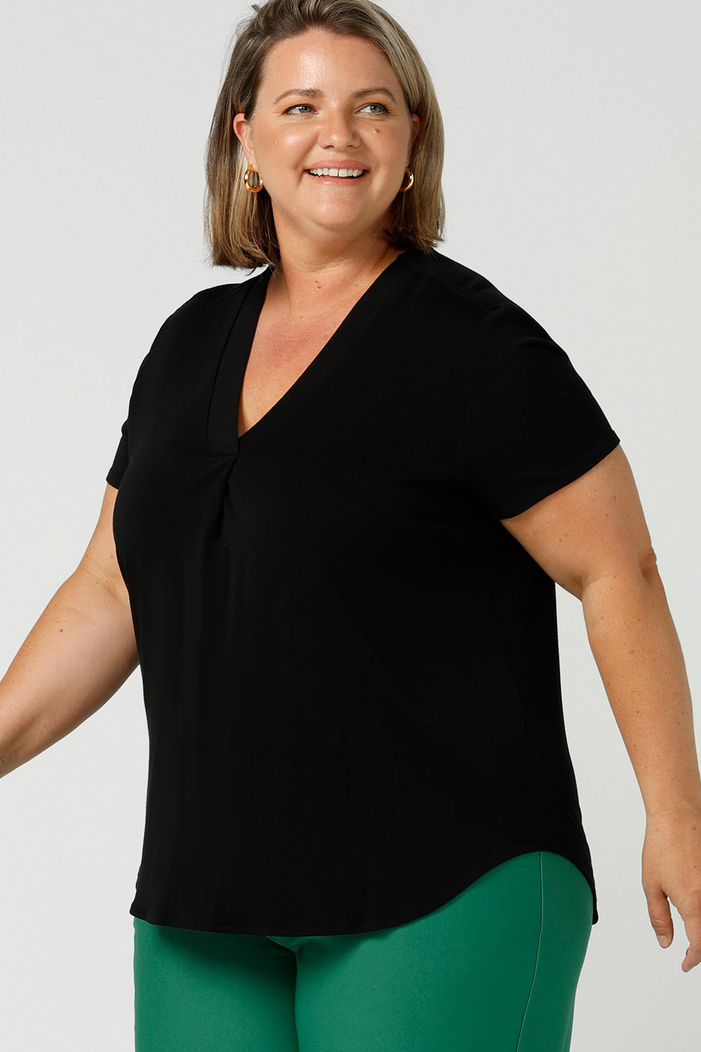 A good top for your capsule wardrobe, this V-neck black bamboo jersey top with short sleeves makes for a good office wear top for women, as well as a comfortable casual top. Shown on a size 18, curvy woman, this is a good top for plus size women. Made by women's clothing brand Australia,  Leina & Fleur, shop black tops for women in sizes 8 to 24 in their online clothing boutique.