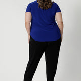 Plus sized woman seen wearing stylish and versatile workwear top from an Australian-made, plus-sized friendly fashion brand, Leina & Fleur. Offering sizes 8 through 24 to ensure a perfect fit for a wide range of body types. Crafted from high-quality dry-touch jersey, the fabric boasts a luxurious feel that is smooth to the touch and breathable, providing long-lasting comfort throughout the workday.