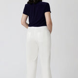 back view of a navy summer top worn with white pants