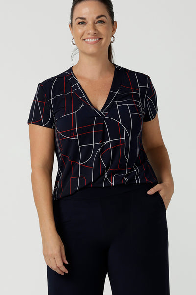 Close up of a size 12 women wears a Emily Top in Navy Abstract print. V-neckline with short sleeves on a navy base colour. Geometric print perfect for a corporate office look. Made in Australia for women size 8 - 24.