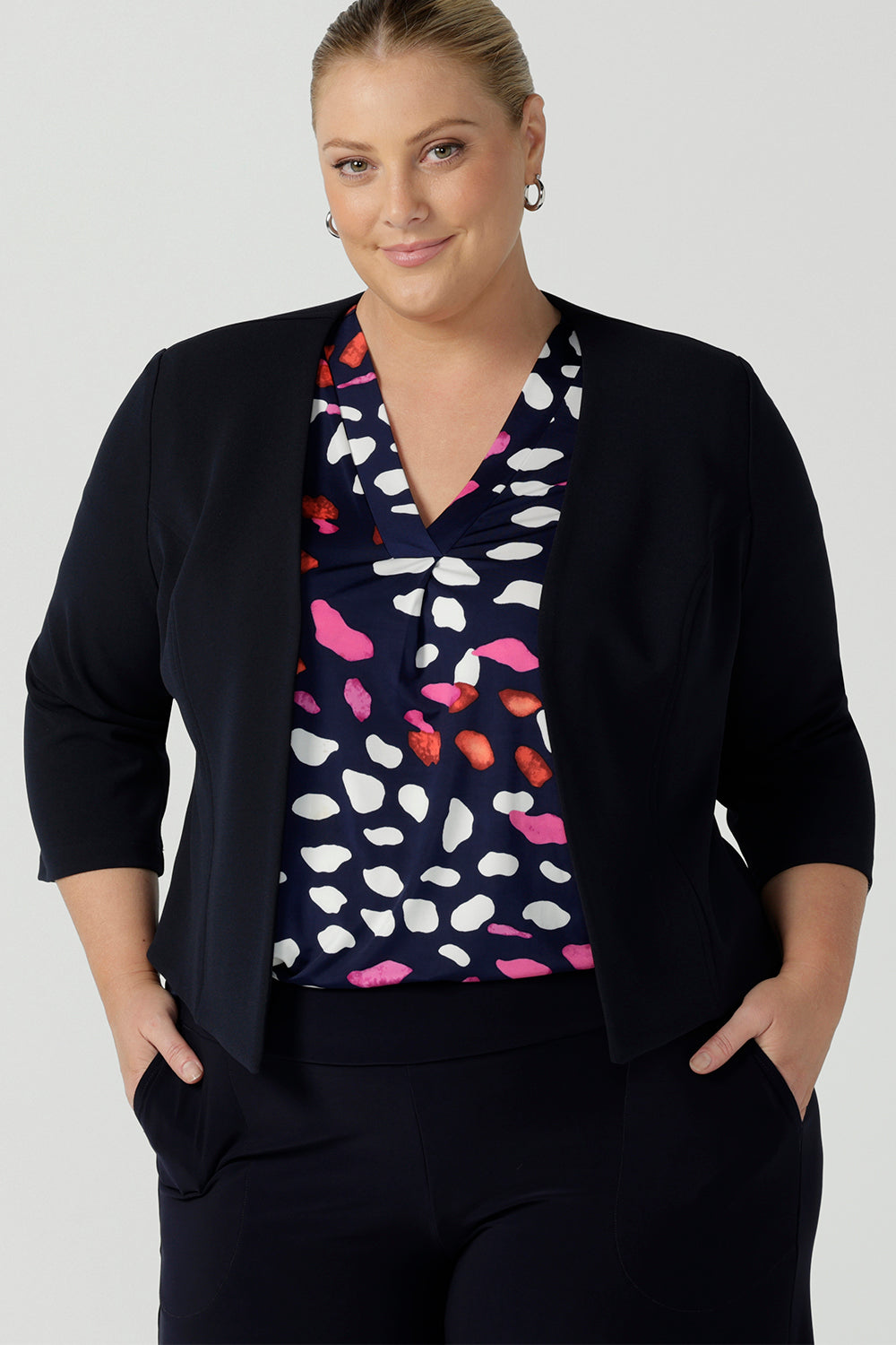 Pictured on a a curvy size 18 woman. Australian made open-fronted collarless tailored jacket for stylish corporate women. A soft tailoring jacket in stretch scuba crepe jersey, the Rainy Jacket is collarless and open-fronted with cropped sleeves. Womens size inclusive fashion from petite to plus size 8 - 24.