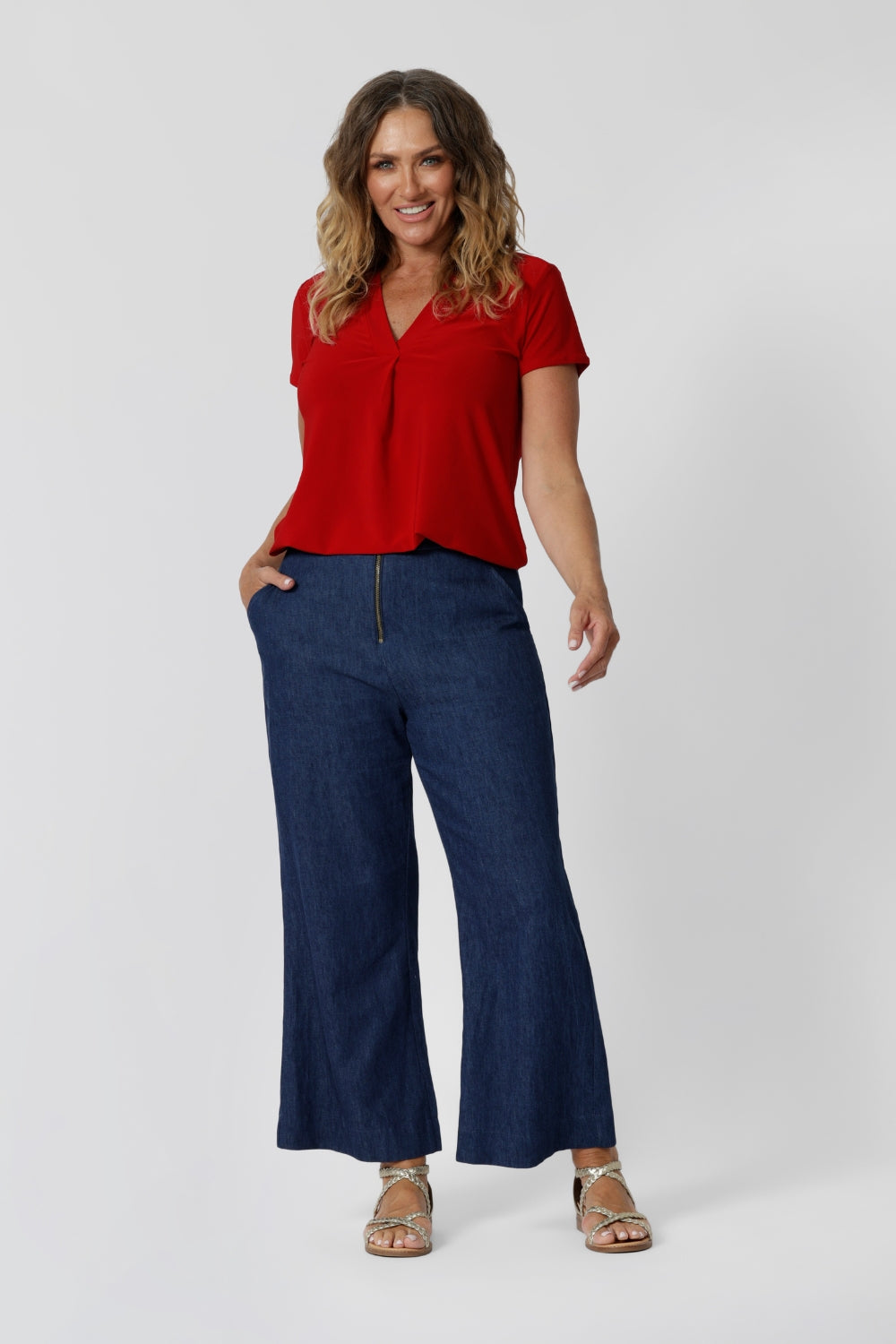 Over 40 year old woman wear red sleeved, v neck top. Australian made from dry touch jersey fabric ensuring a soft, dry feel when wearing -  perfect for the summer heat. This red shirt is an ideal piece for travel as it the dry touch fabric is wrinkle resistant. Shop now in sizes 8-24. Leina & Fleur stock petite and plus sizes. 