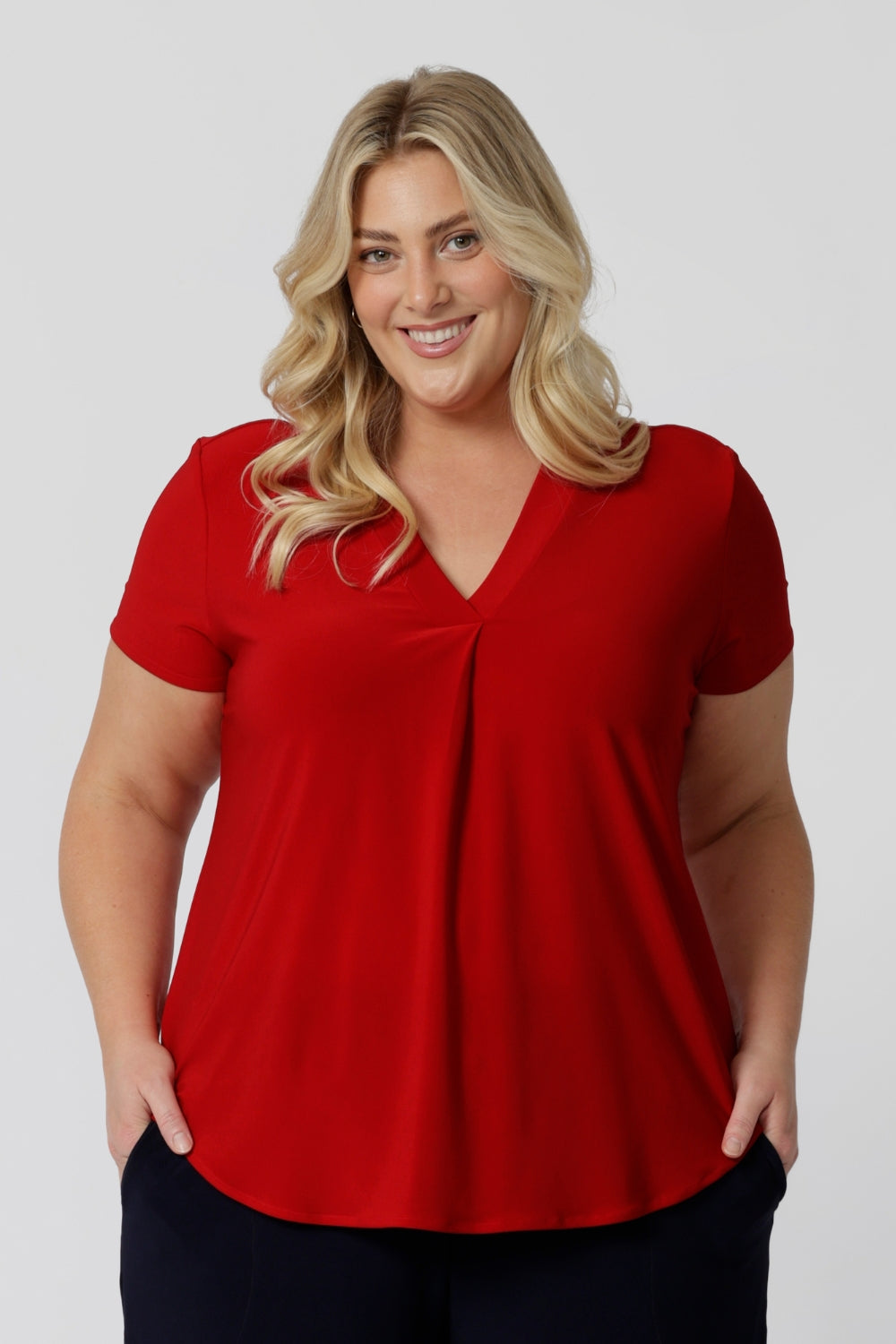 Plus sized woman wears sleeved red top. Australian made from dry touch jersey fabric ensuring a soft, dry feel perfect for the warmer months. This red shirt is an ideal piece for travel as the dry touch fabric is wrinkle resistant. Fashion brand  Leina & Fleur proudly stock petite and plus sizes. Shop now in sizes 8-24.